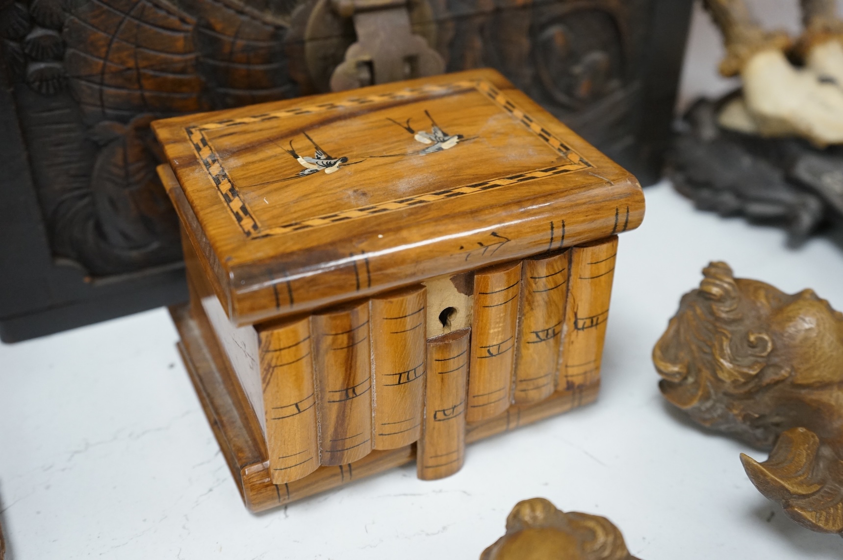 A Chinese carved wood box, two pairs of mounted deer horns, two carved wood cherub heads, an ashtray and an olivewood box, large box 29.5cm x 15cm high. (7)